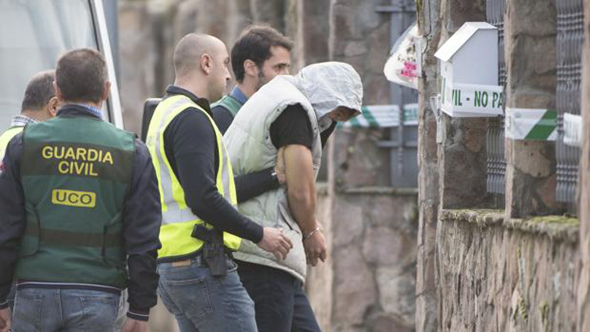 Patrick Nogueira Gouveia escoltado por agentes de la Guardia Civil a su llegada al chalet de la localidad de Pioz, donde aparecieron muertos sus tíos y los hijos de estos, de 4 y 1 años, para reconstruir los hechos (EFE/Pepe Zamora)