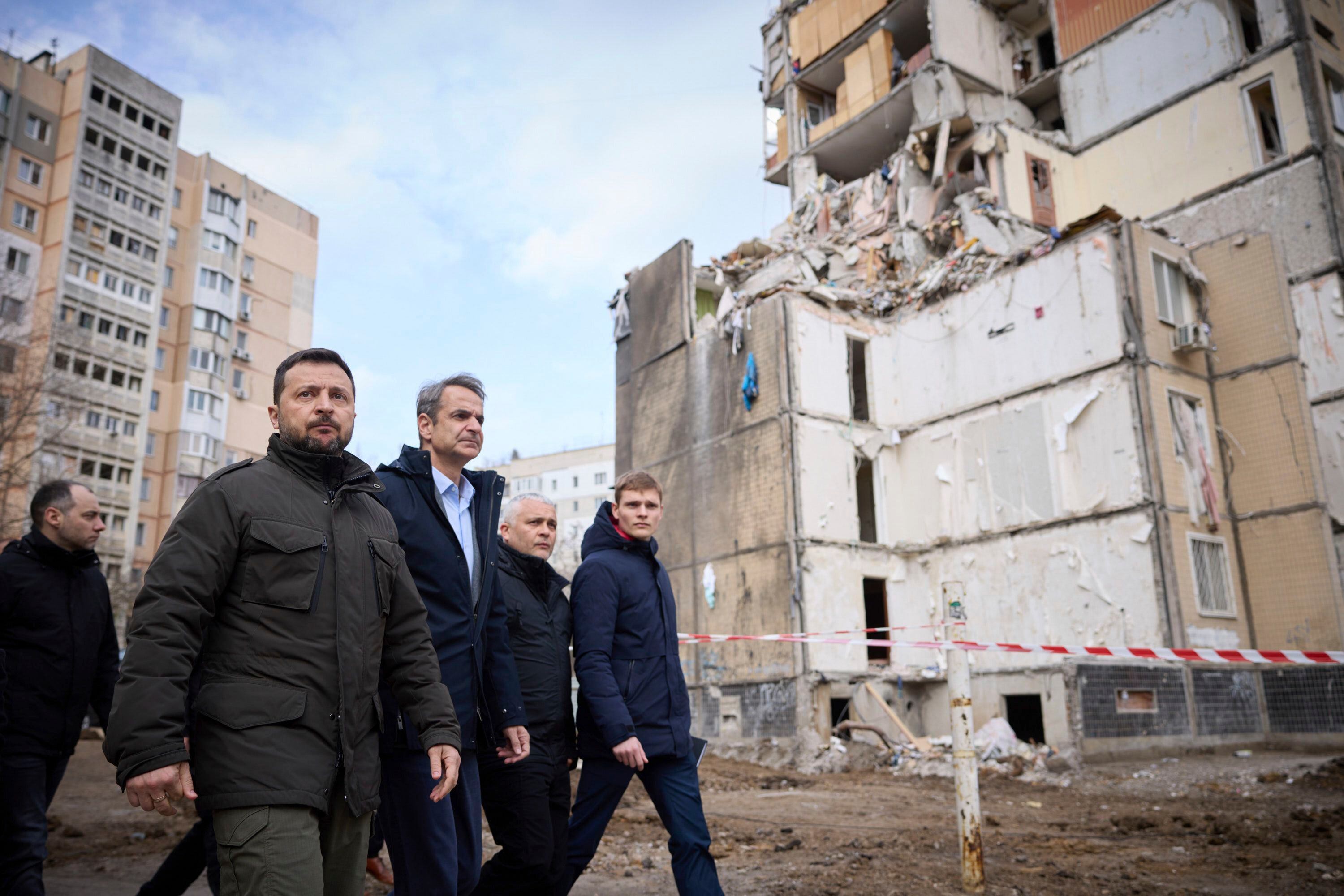 En esta foto distribuida por la Oficina de Prensa de la Presidencia de Ucrania, el presidente ucraniano Volodymyr Zelensky, 2do izquierda, y el primer ministro de Grecia, Kyriakos Mitsotakis, 3ro izquierda, caminan por una zona residencial dañada por un ataque ruso en Odessa, miércoles 6 de marzo de 2024 (Oficina de Prensa de la Presidencia de Ucrania via AP)