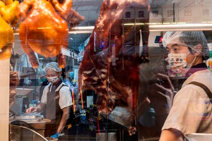 Unos cocineros con mascarillas trabajan en un restaurante cantonés en Hong Kong (EFE) 