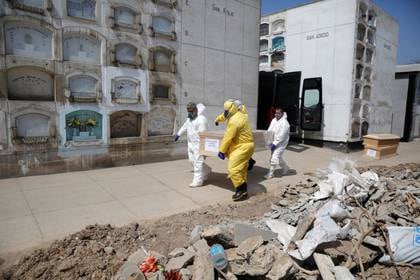 Trabajadores funerarios trasladan un atúd con el cuerpo de una persona fallecida por COVID-19, en un cementerio en Lima, Perú. 9 de mayo de  2020 (REUTERS/Sebastian Castaneda)