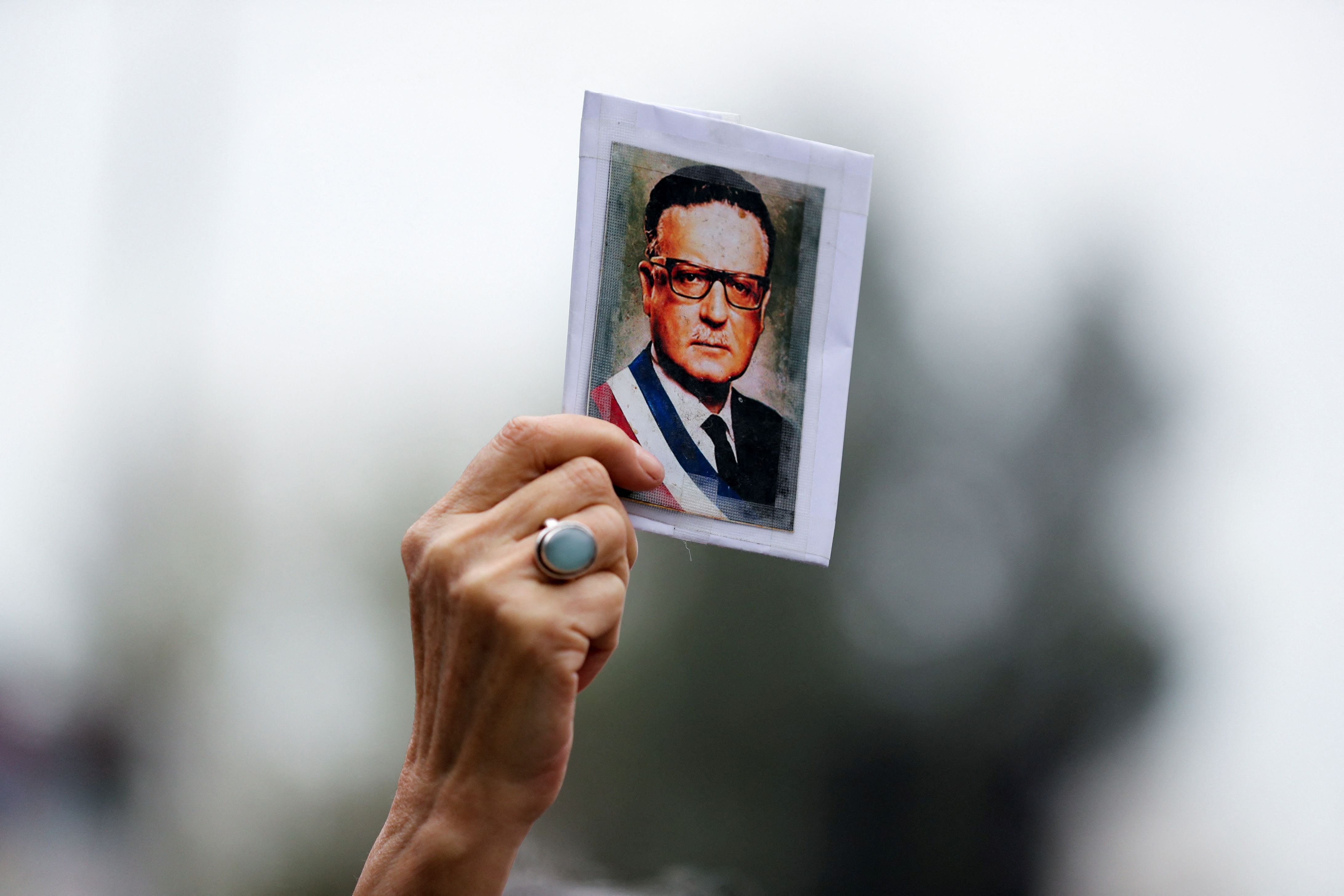 Una persona sostiene una foto del ex presidente de Chile Salvador Allende mientras los manifestantes asisten a una manifestación-marcha antes del 50 aniversario del golpe militar chileno de 1973, en Santiago, Chile, 10 de septiembre de 2023 (Reuters)