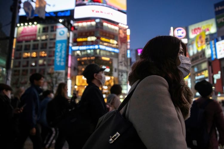 FOTO DE ARCHIVO: Una mujer con una marcarilla protectora es vista en el cruce de caminos en el distrito comercial de Shibuya en Tokio, tras el brote del coronavirus en Japón, 3 de marzo, 2020. REUTERS/Athit Perawongmetha/Foto de Archivo