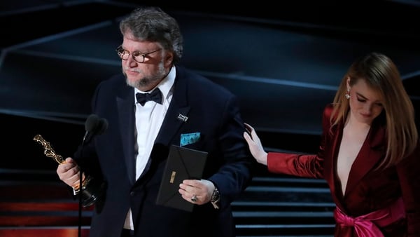 Del Toro tras recibir su premio de mano de Emma Stone, ganadora como Mejor actriz en 2017 por “La La Land” (Reuters)