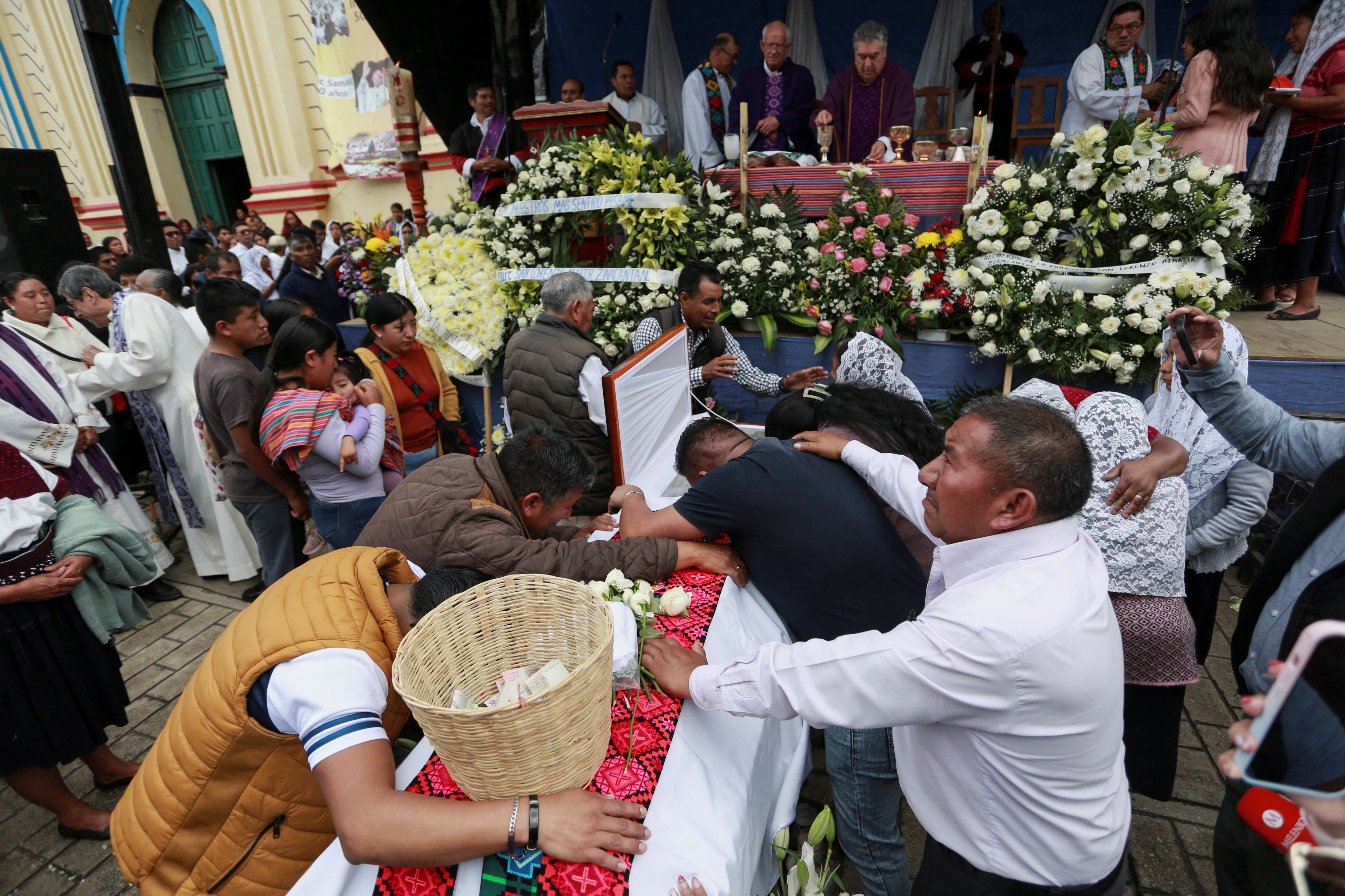 Feligreses y familiares rodean el ataúd con el cuerpo del sacerdote Marcelo Pérez, quien fue asesinado el domingo en San Cristóbal de las Casas después de oficiar una misa, durante una misa fúnebre, en San Andrés Larraínzar, en el estado sureño de Chiapas, México, el 21 de octubre. 2024. REUTERS/Gabriela Sanabria