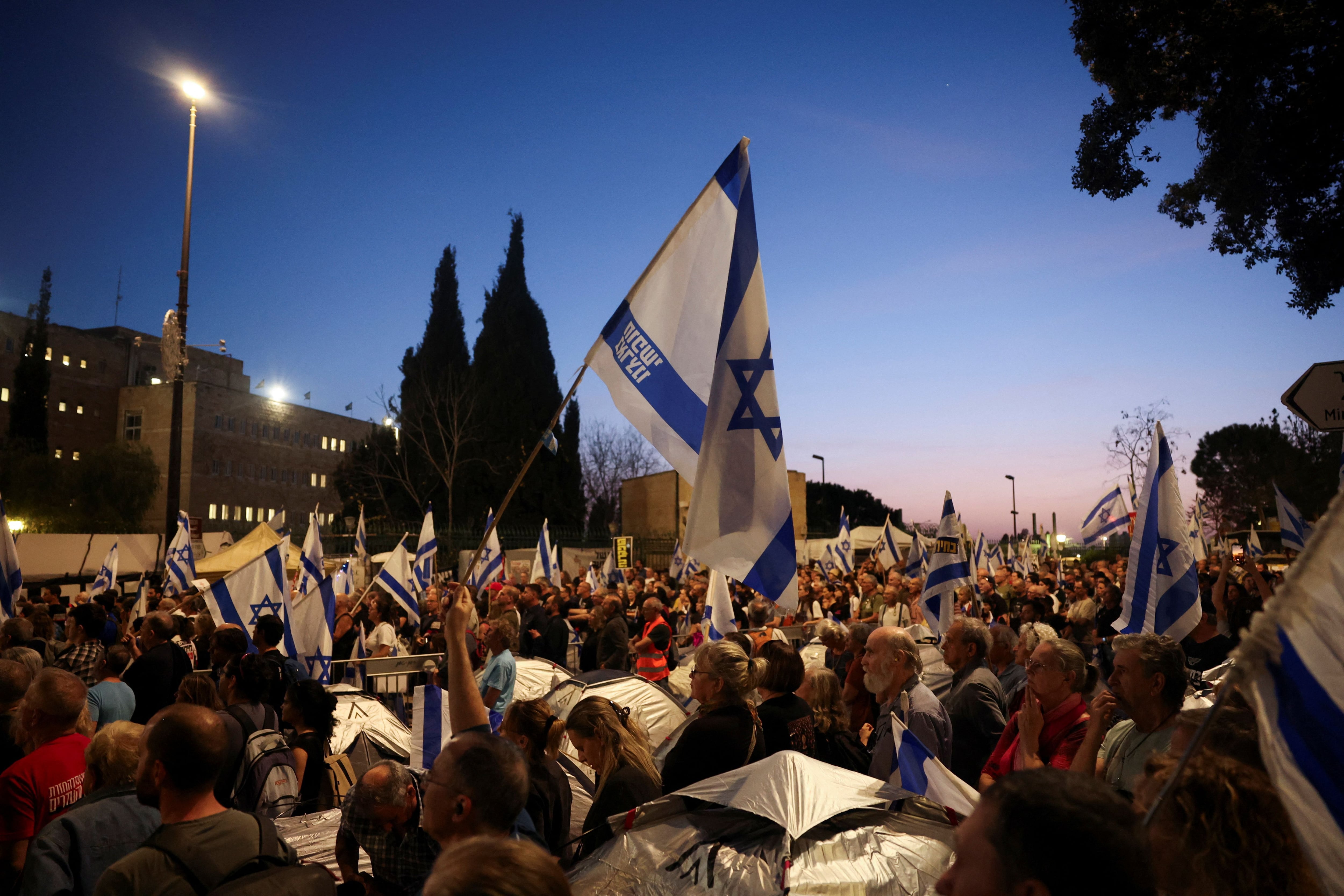 Los manifestantes sostienen carteles y banderas mientras exigen el derrocamiento del primer ministro israelí, Benjamin Netanyahu, tras el mortal ataque del 7 de octubre contra Israel por parte del grupo islamista palestino Hamás y la consiguiente guerra en Gaza, en una manifestación en Jerusalén, el 1 de abril de 2024. REUTERS/Ronen Zvulun