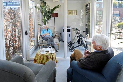 Un hombre visita a su esposa en un centro de atención para ancianos con demencia, en una casa de cristal que hecha especialmente contra la soledad causada por la prohibición de visitas debido al brote de coronavirus en Wassenaar, Holanda, el 9 de abril de 2020 (REUTERS/Piroschka van de Wouw/Archivo Foto)