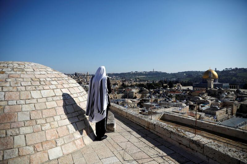 Un adorador judío está de pie en una azotea con vistas al Muro de las Lamentaciones (REUTERS/Ronen Zvulun)