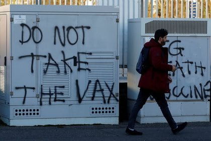 File foto: una persona passa graffiti anti-vaccino tra lo scoppio della malattia da virus corona (COVID-19) il 1 ° gennaio 2021 a Belfast, nell'Irlanda del Nord.  REUTERS / Bill Noble 