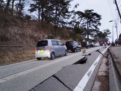 Varias personas caminan por una carretera dañada por el terremoto en Wajima (Kyodo via REUTERS)