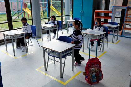 Estudiantes atienden en clase con los pupitres separados respetando las recomendaciones para evitar el contagio por la covid-19 hoy, durante el retorno a clases presenciales bajo el modelo de alternancia, en Bogotá (Colombia). EFE/ Mauricio Dueñas Castañeda
