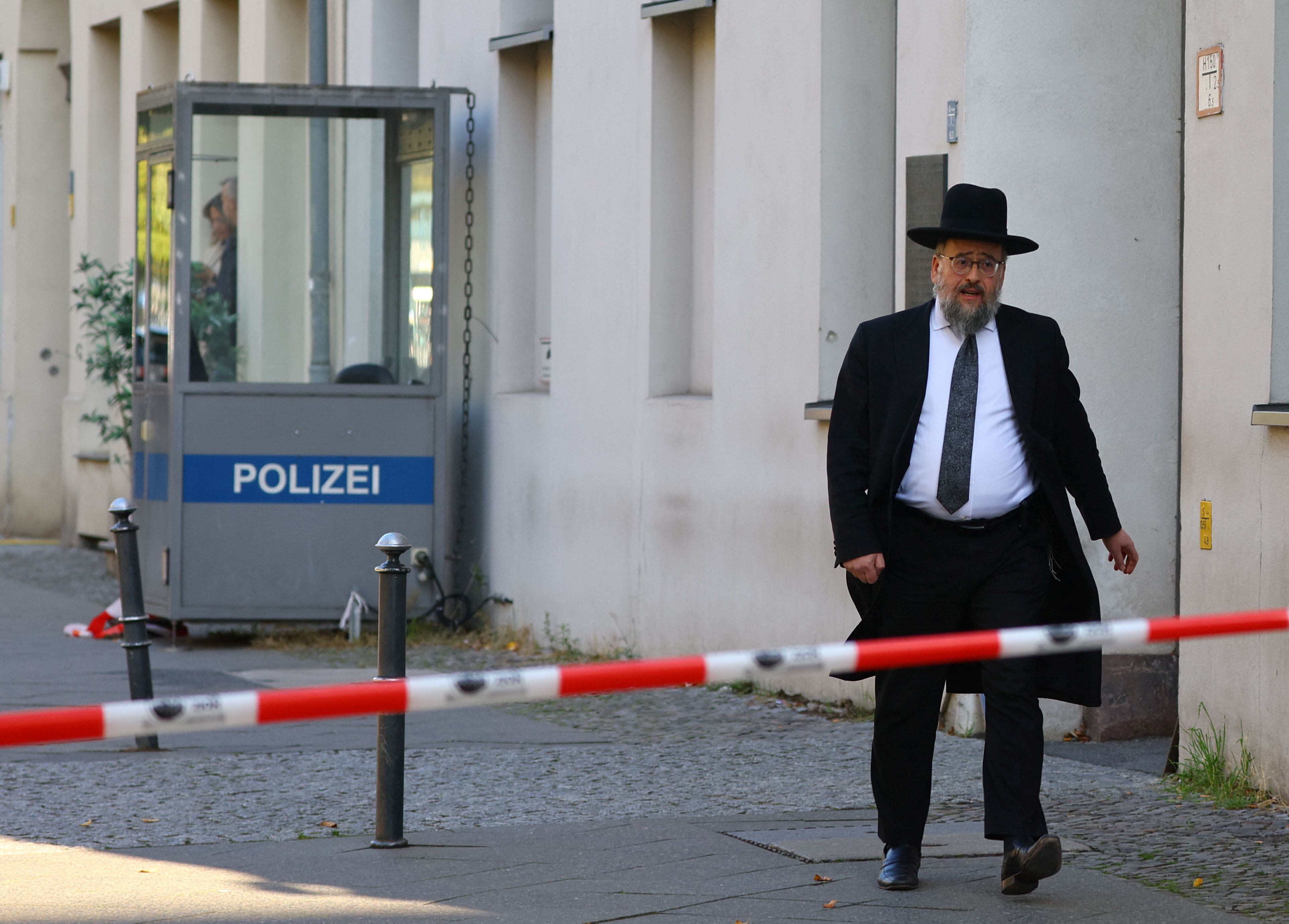 Un miembro de la comunidad judía camina detrás de la cinta de barrera tras el bloqueo policial de la zona después de que se lanzaran dos cócteles molotov contra la Sinagoga y Centro Educativo Skoblo durante la noche en Berlín, Alemania, 18 de octubre de 2023. REUTERS/Fabrizio Bensch