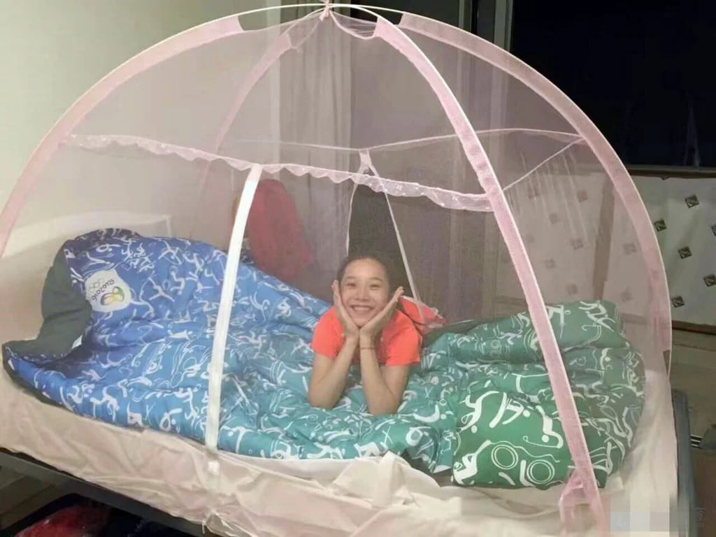 Las atletas chinas posaron dentro del mosquitero que las protegerá del zika mientras duermen