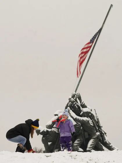 Después de que una Nevada cubriera la región de Washington, un niño lame una bola de nieve mientras jugaba en el Marine Corps War Memorial en Arlington, Virginia, EE.UU., el 16 de enero de 2024. REUTERS/Kevin Lamarque