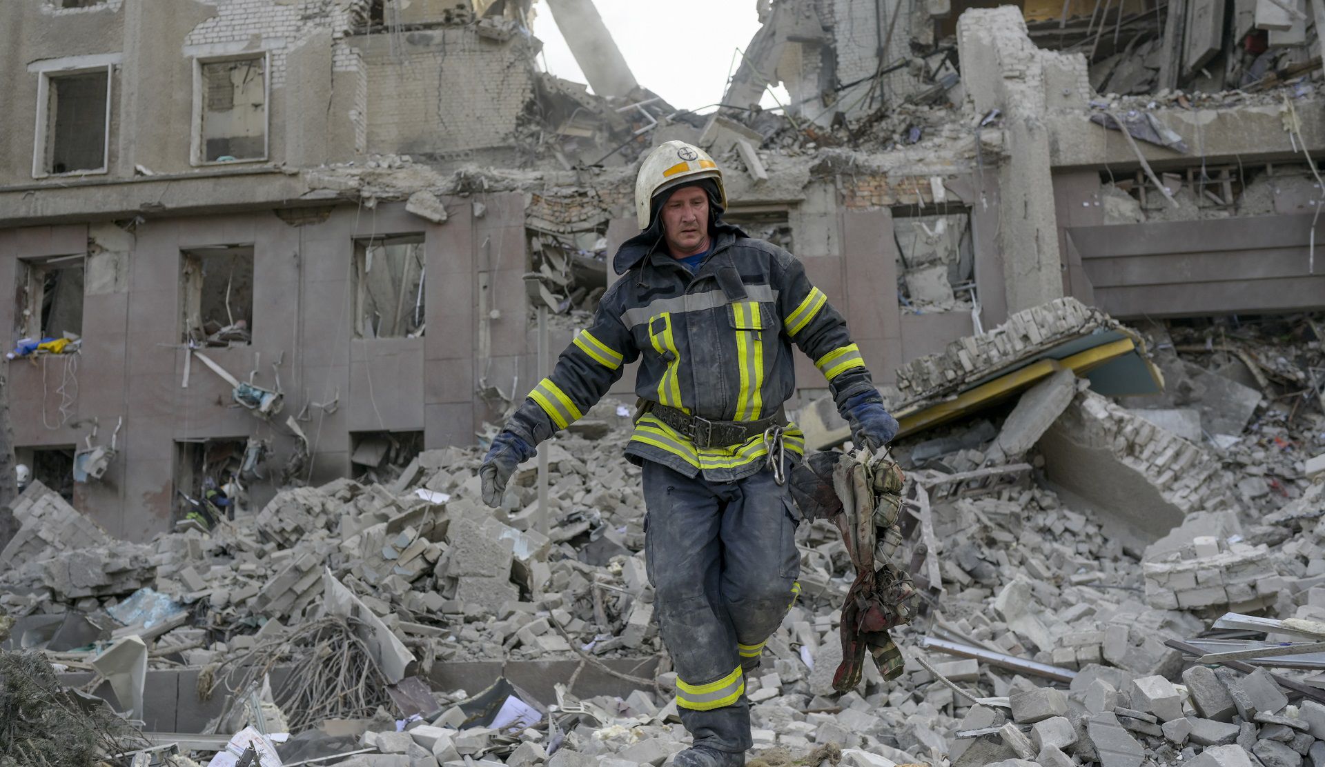 A firefighter clears the rubble of a government building hit by Russian rockets in Mykolaiv on March 29, 2022. - A Russian strike battered the regional government building in the southern Ukrainian city of Mykolaiv, a key port under heavy assault for weeks, the regional governor said on March 29, 2022. Governor Vitaly Kim said that most people inside the building had not been injured but several civilians and soldiers were unaccounted for. (Photo by BULENT KILIC / AFP)