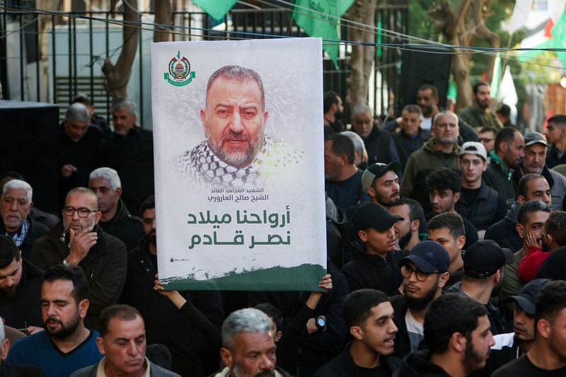 Una persona sostiene una pancarta con la foto del difunto líder adjunto de Hamás Saleh al-Arouri durante el funeral de Ahmad Hammoud, que murió junto con al-Arouri en lo que, según fuentes de seguridad, fue un ataque israelí con drones en Beirut el martes, en Burj al-Shemali en Tiro, Líbano. 3 de enero de 2024. REUTERS/Aziz Taher