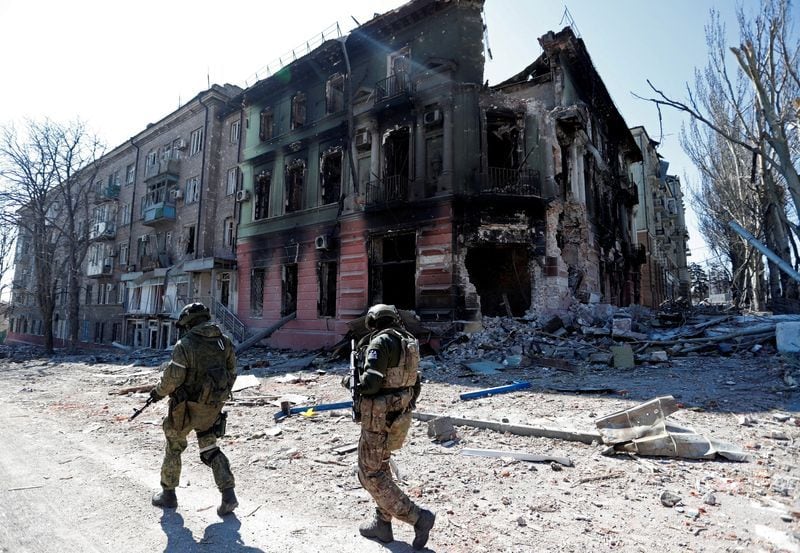 Miembros de servicio de las tropas prorrusas patrullan una de las zonas destruidas por los bombardeos en Mariupol. REUTERS/Alexander Ermochenko.