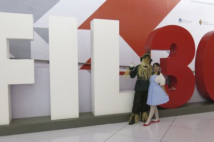 ARCHIVO – En esta fotografía de archivo del 28 de noviembre de 2016 promotores de "El Libro Total" vestidos como personajes del Mago de Oz posan junto a un letrero de la Feria Internacional del Libro de Guadalajara en Guadalajara, México. La FIL Guadalajara será virtual en su edición 2020 por la pandemia de COVID-19 y se celebrará del 28 de noviembre al 6 de diciembre. (Foto AP/Berenice Bautista, archivo)