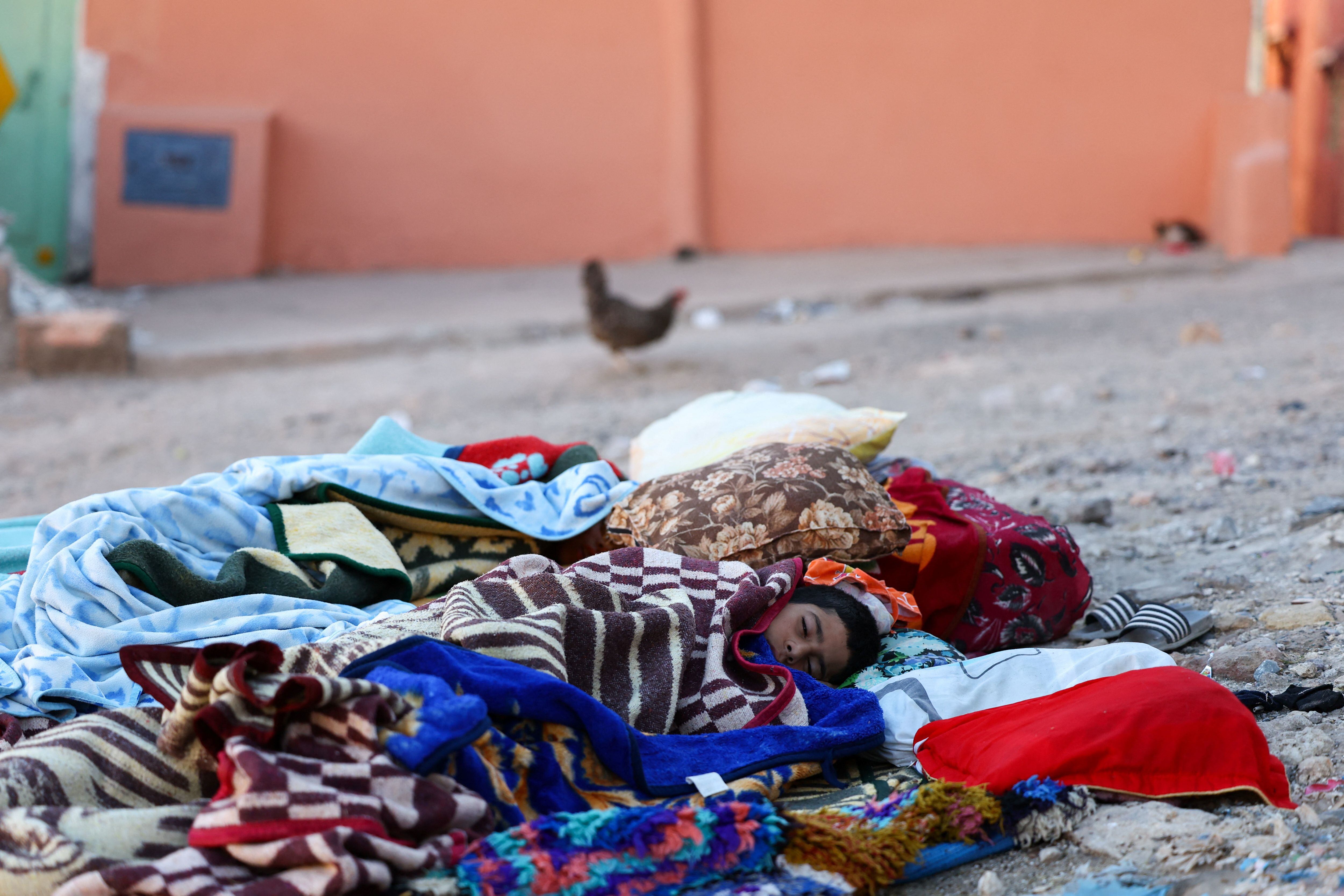 La gente descansa en el suelo tras un mortal terremoto en Moulay Brahim. REUTERS/Hannah McKay
