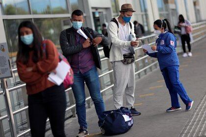 File photo.  A Red Cross employee wearing a face mask talks to a passenger, after the Cclombia Government authorized to reactivate international flights, amid the coronavirus pandemic, in Bogotá, Colombia, September 21, 2020. REUTERS / Luisa Gonzalez