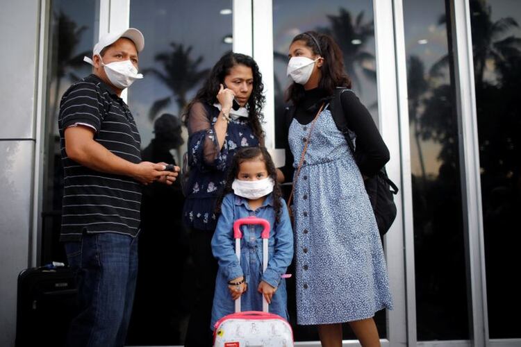 Imagen de archivo. Una familia de viajeros reaccionó a las medidas cada vez más estrictas del gobierno salvadoreño para prevenir una posible propagación del coronavirus (COVID-19), en el Aeropuerto Internacional Saint Oscar Romero en San Luis Talpa, El Salvador. 16 de marzo de 2020. REUTERS / Jose Cabezas