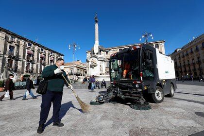 Trabajadores limpian una plaza después de una impresionante erupción volcánica del Monte Etna en Catania, Italia, el 17 de febrero de 2021. REUTERS / Antonio Parrinello