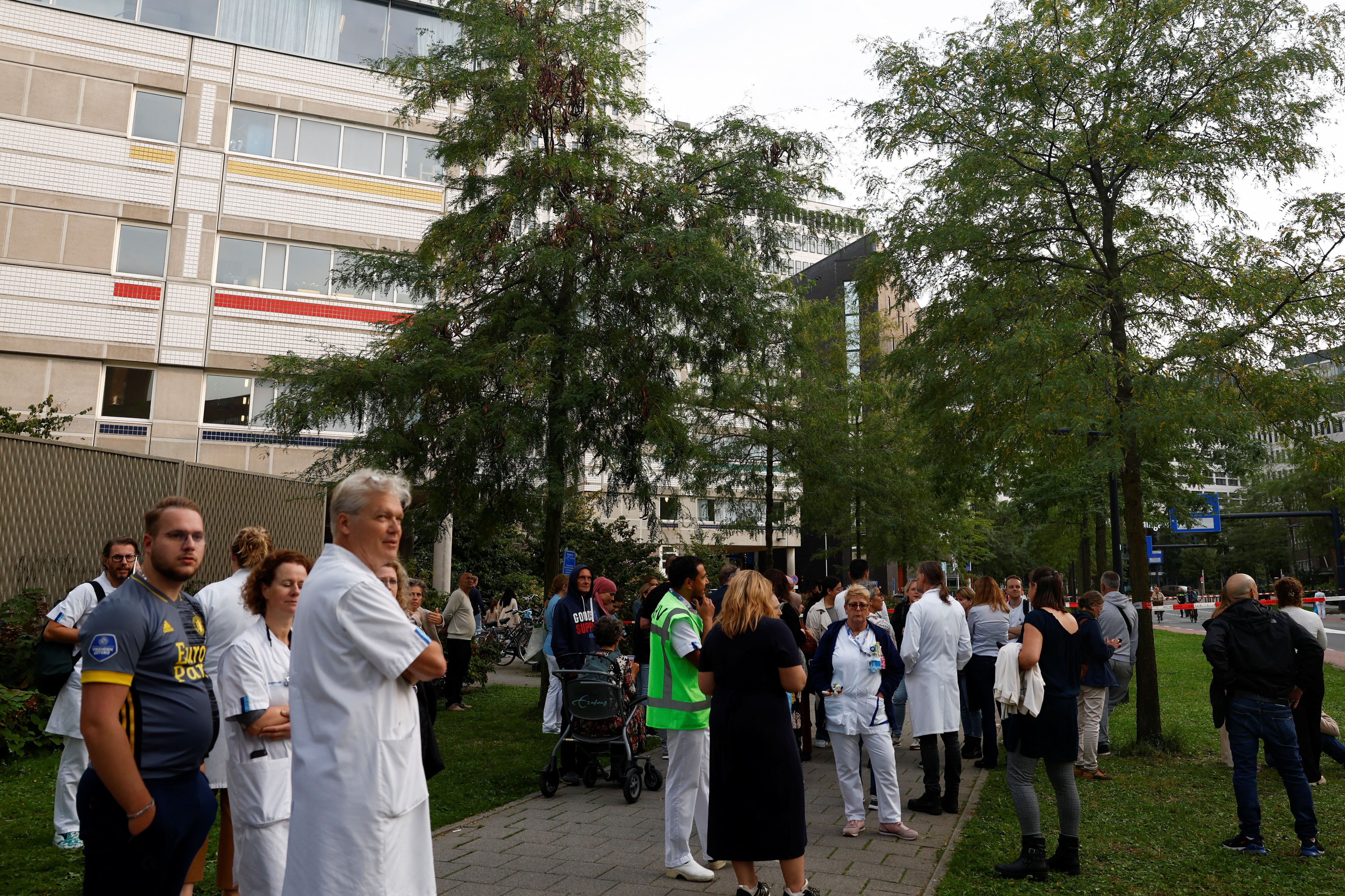 Un grupo de médicos observa el operativo policial en un hospital de Rotterdam tras la detención de un sospechoso luego de un tiroteo este 28 de septiembre de 2023 (REUTERS/Piroschka van de Wouw)