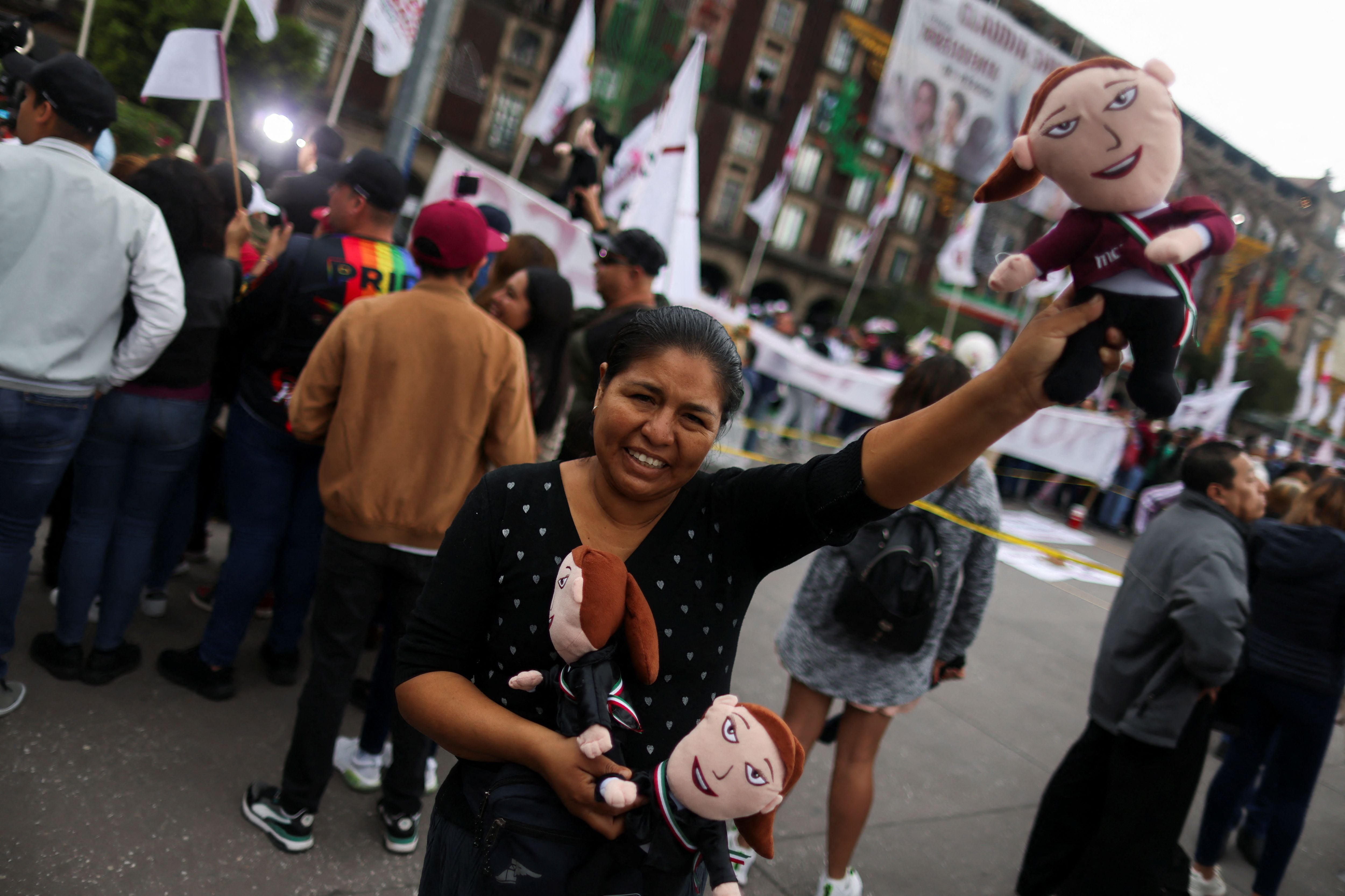 A person holds dolls depicting Mexico's new President Claudia Sheinbaum as supporters gather for a ceremony where Sheinbaum will receive the 