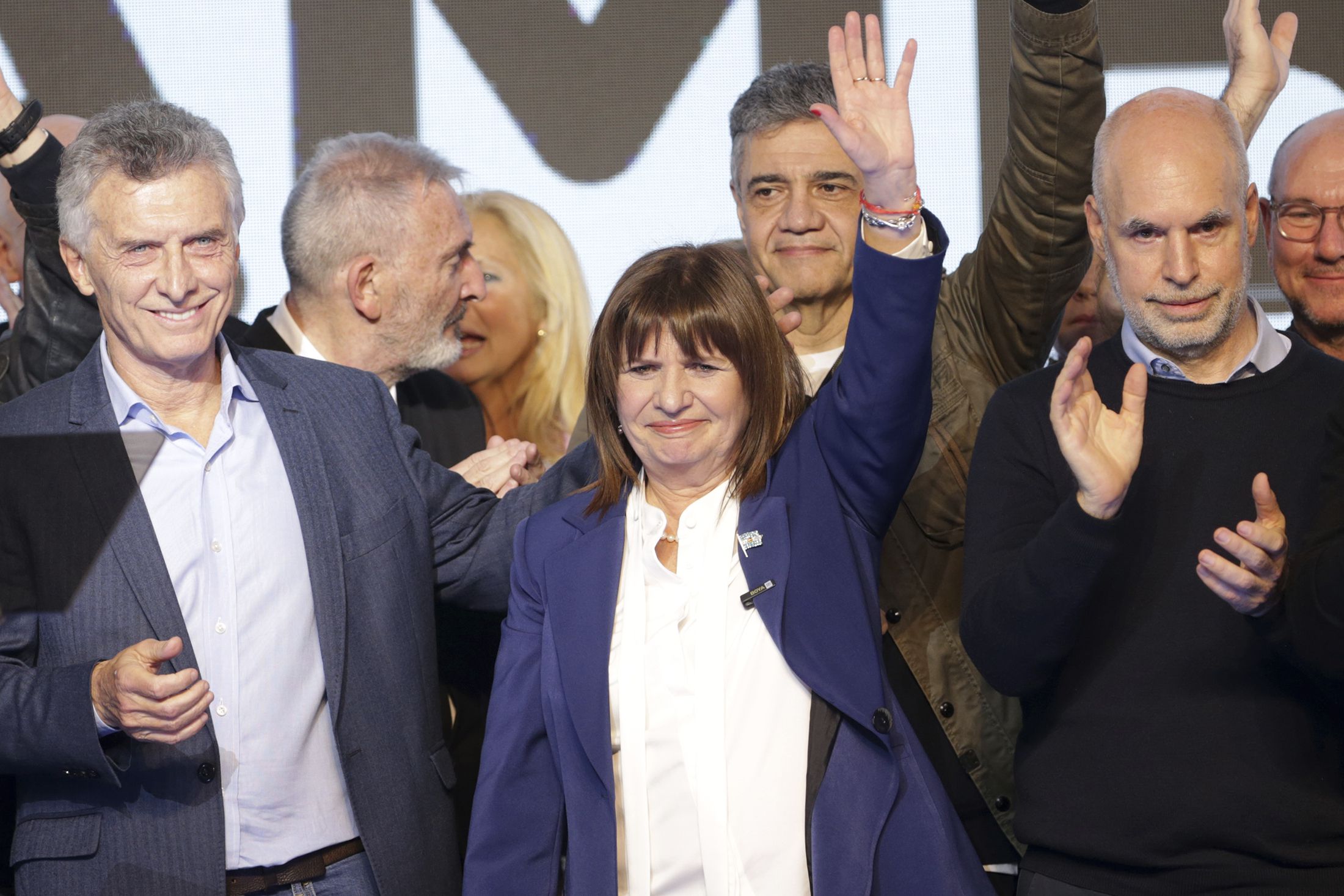 La candidata presidencial Patricia Bullrich, al centro, el excandidato Horacio Rodríguez Larreta, a la derecha, y el expresidente argentino Mauricio Macri, a la izquierda, celebran en la sede de la campaña de la coalición Juntos por el Cambio tras PASO. (AP Foto/Daniel Jayo)