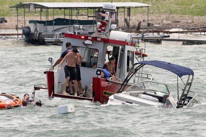 Una embarcación ayuda a las personas que quedaron en el agua tras el hundimiento de su nave (Reuters)