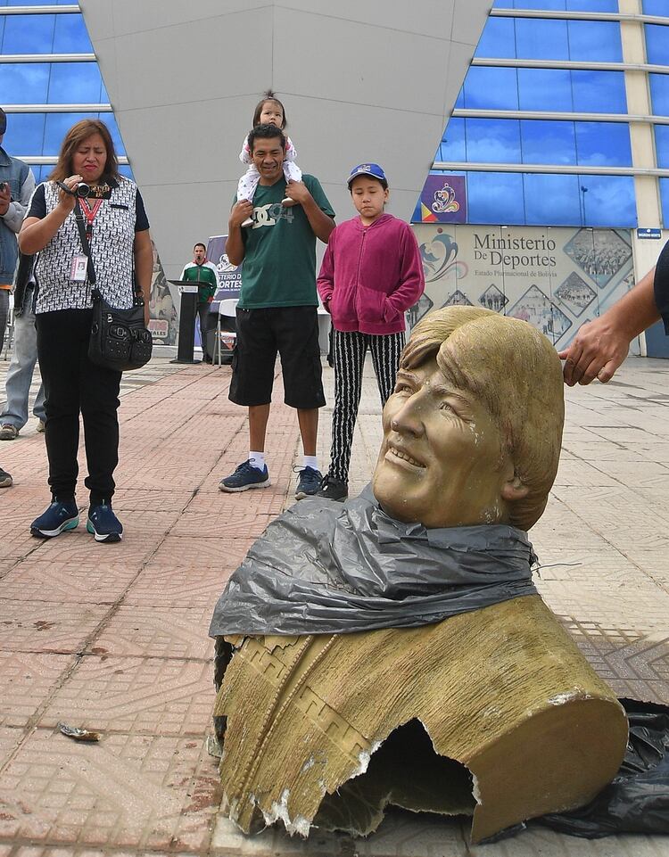 Un grupo de personas toma fotografías y videos de un busto de Evo Morales que fue retirado este lunes en Quillacollo (EFE/Jorge Abrego)