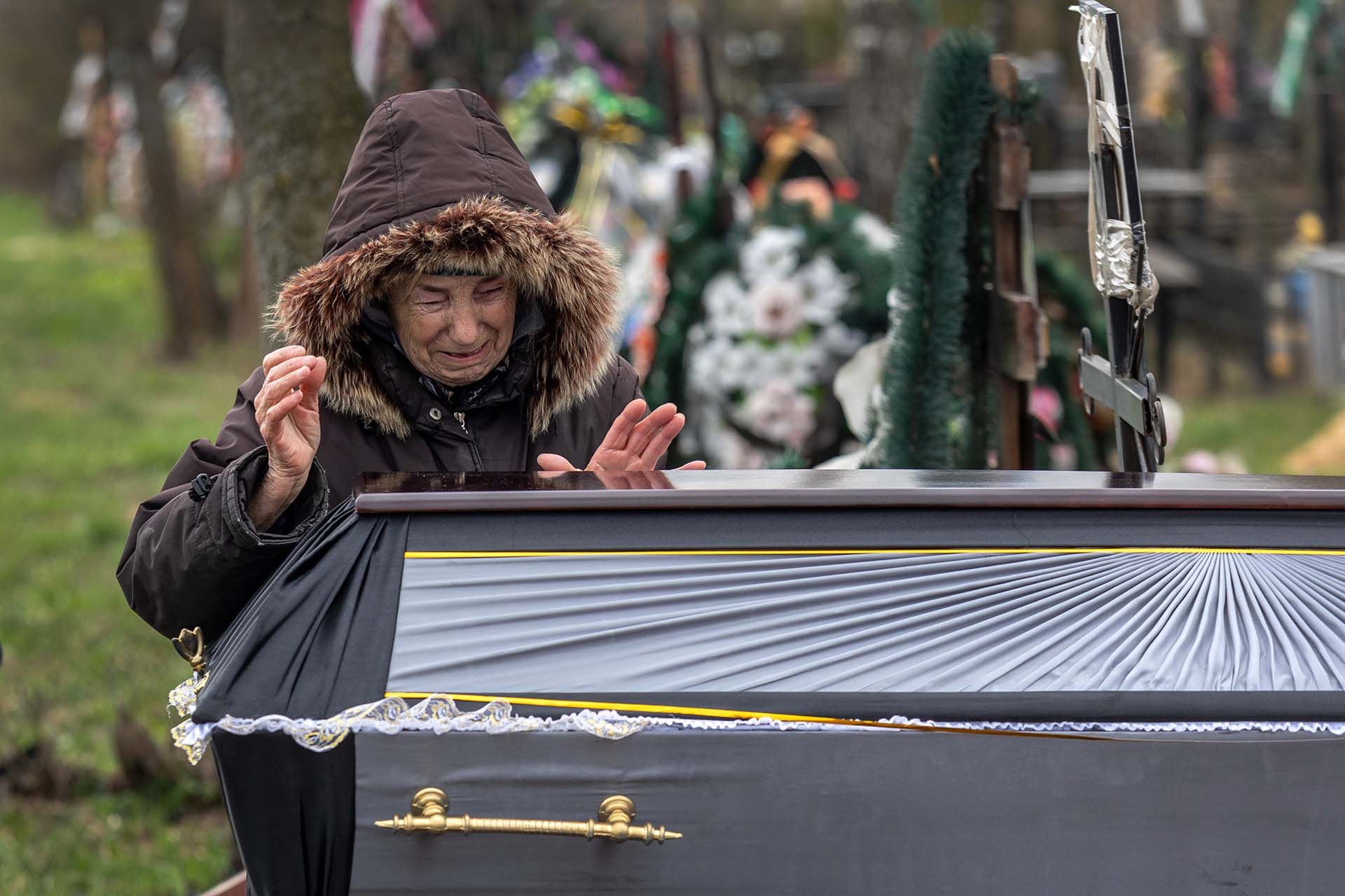 Valentyna Nechyporenko, de 77 años, llora ante la tumba de su hijo Ruslan Nechyporenko, de 47 años, durante su funeral el 18 de abril de 2022 en Bucha, Ucrania. Su cuerpo fue encontrado en Bucha después de que los soldados rusos se retiraran semanas antes, siendo uno de los al menos 700 civiles asesinados encontrados en pueblos alrededor de Kiev, según las autoridades.  (Foto de John Moore/Getty Images)