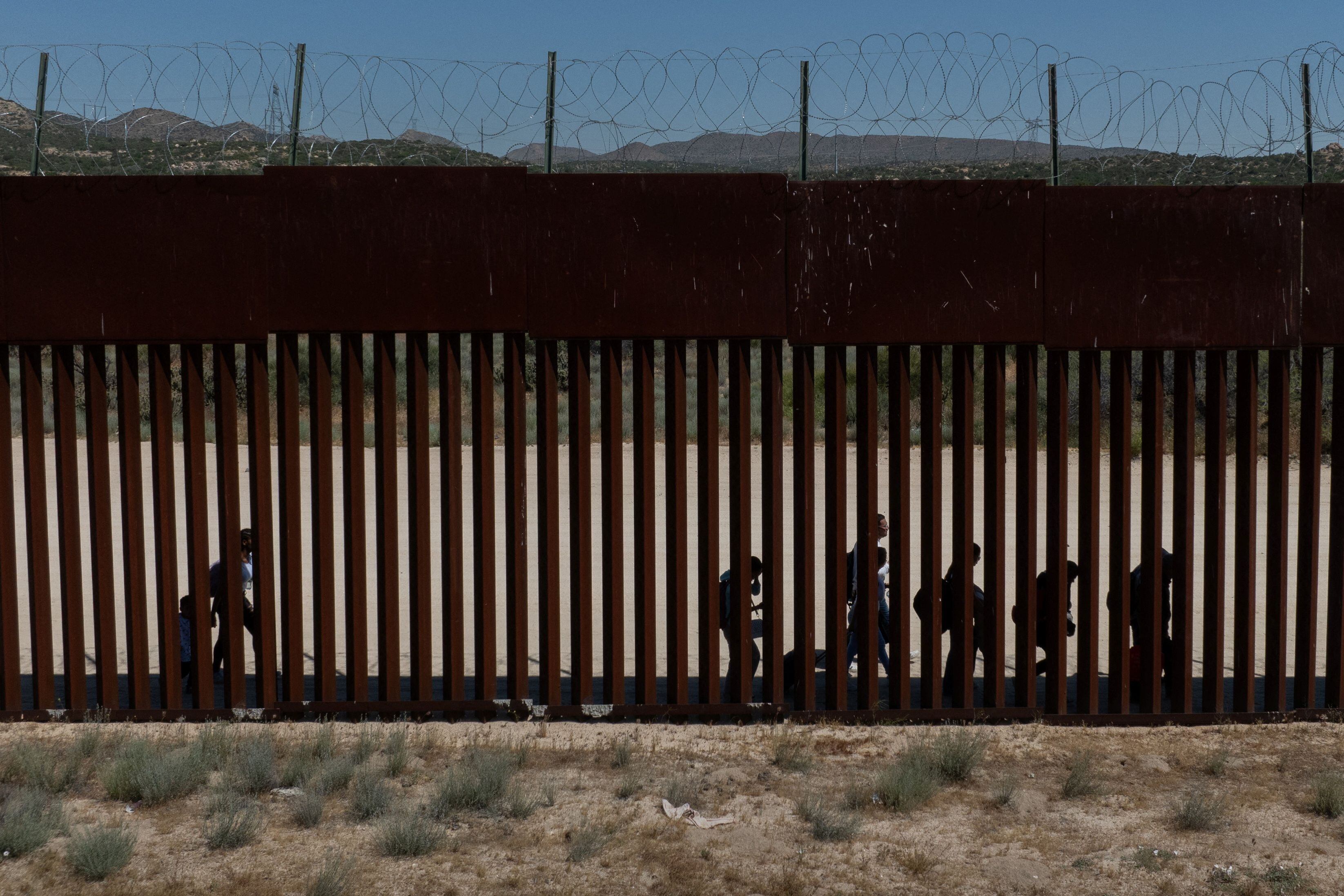 Una vista de un dron muestra a migrantes solicitantes de asilo de Colombia, Perú y Panamá mientras caminan a lo largo del muro fronterizo después de cruzar la frontera hacia los Estados Unidos, en Jacumba Hot Springs, California, Estados Unidos, visto desde México. REUTERS/ Dirección Latif