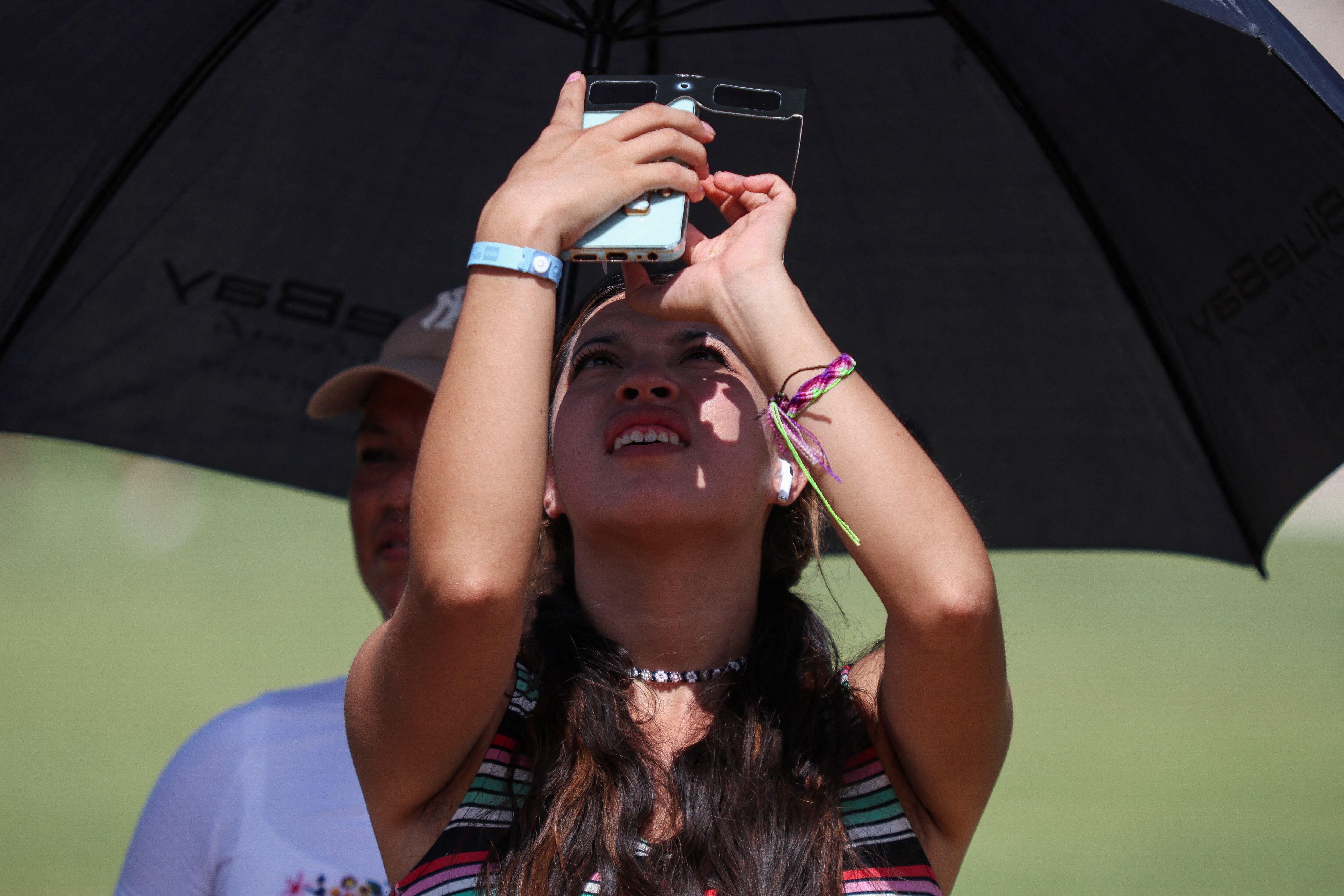 Para tomar fotografías del eclipse desde el celular, se debía situar los lentes en la cámara del dispositivo.  REUTERS/Lorenzo Hernandez