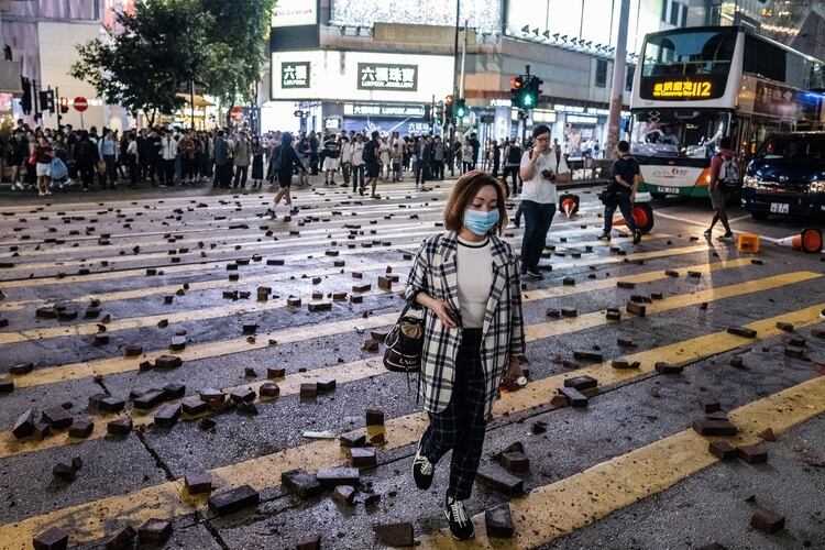 Transeúntes caminan entre los escombros en Hennessy Road en Hong Kong, China (Justin Chin/Bloomberg)