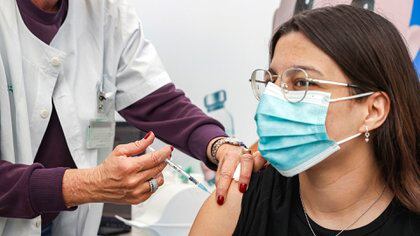 Leehee, una adolescente de 18 años, recibe una dosis de la vacuna contra el coronavirus COVID-19 de Pfizer-BioNtech en los Servicios de Salud de Clalit, en la ciudad costera mediterránea de Tel Aviv, el 23 de enero de 2021 (afp)