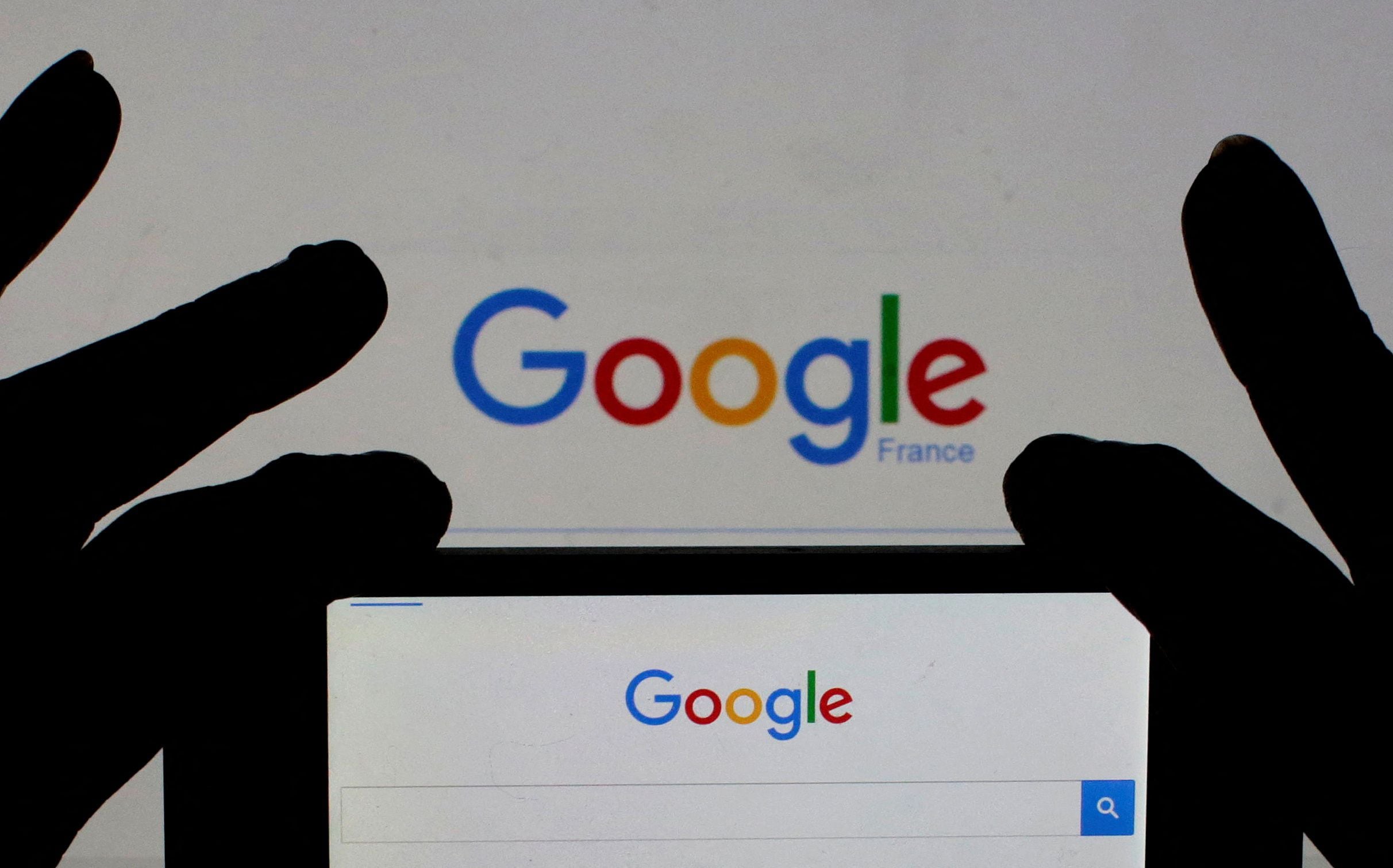 FILE PHOTO: A woman holds her smart phone which displays the Google home page, in this picture illustration taken February 24, 2016. REUTERS/Eric Gaillard/Illustration/Files/File Photo