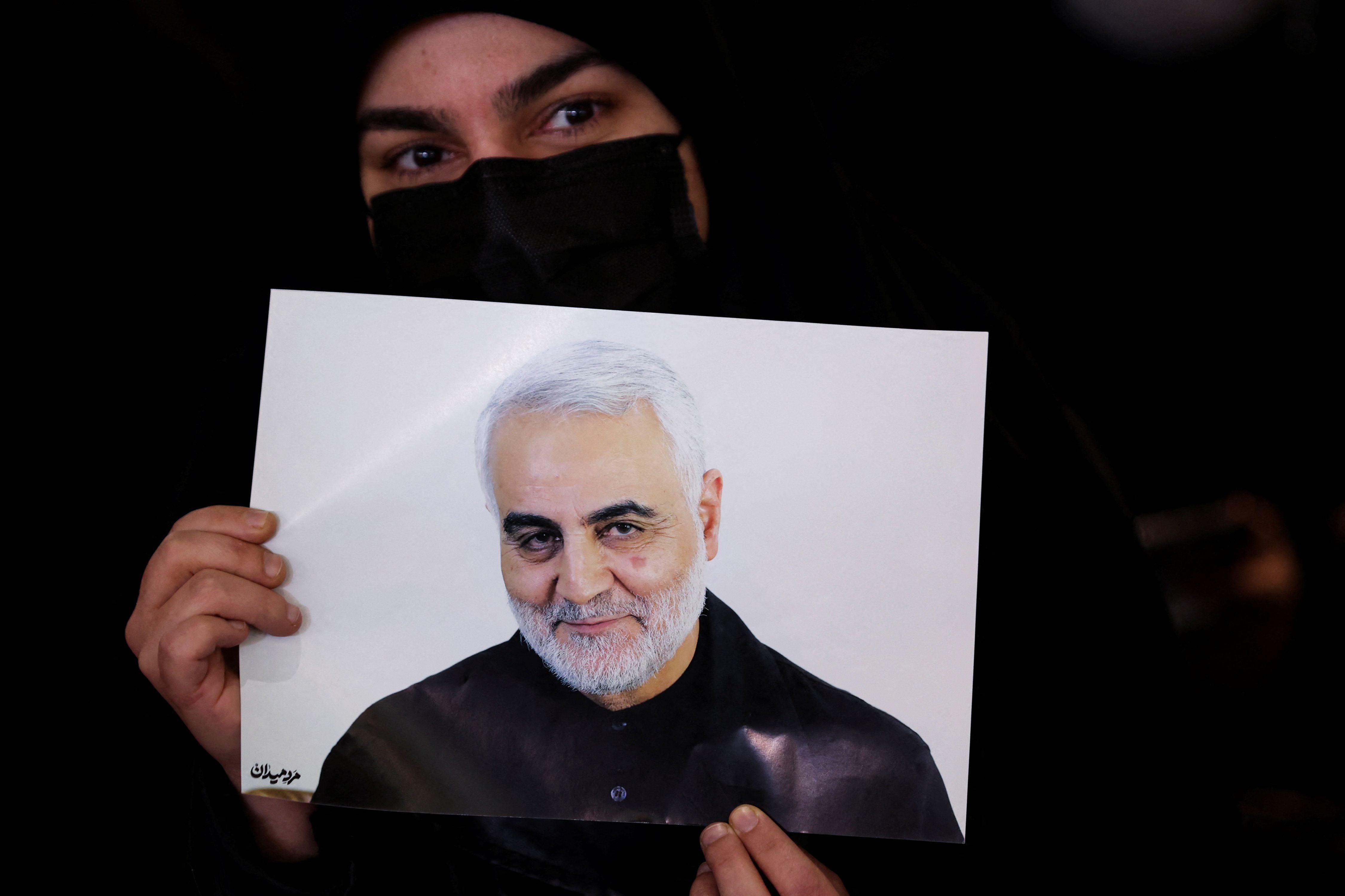 Una mujer sostiene una imagen de Qassem Soleimani (WANA/Reuters)