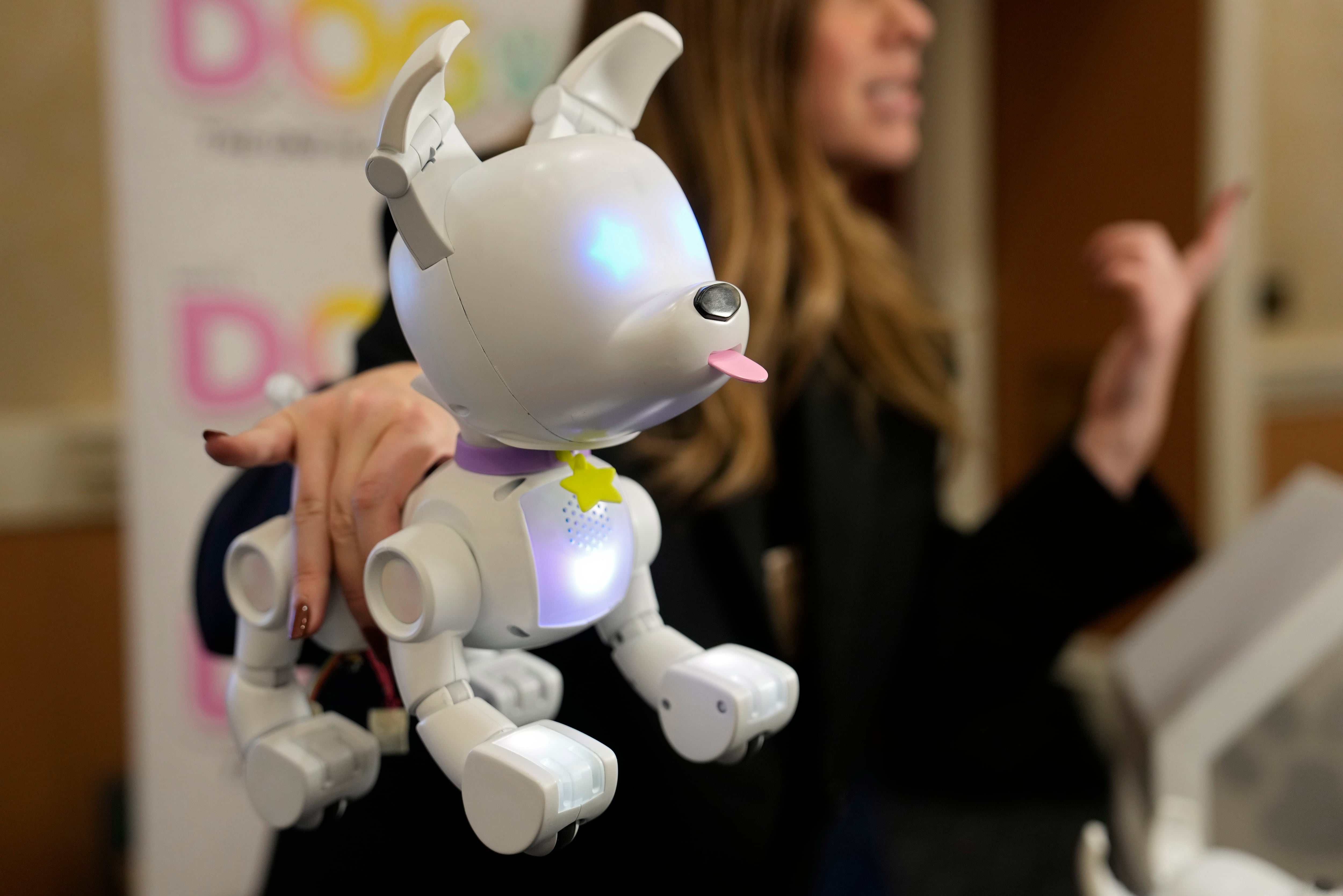 Una expositora sostiene el perro robot Dog-E durante la feria tecnológica CES 2023, en Las Vegas. (Foto AP/John Locher)