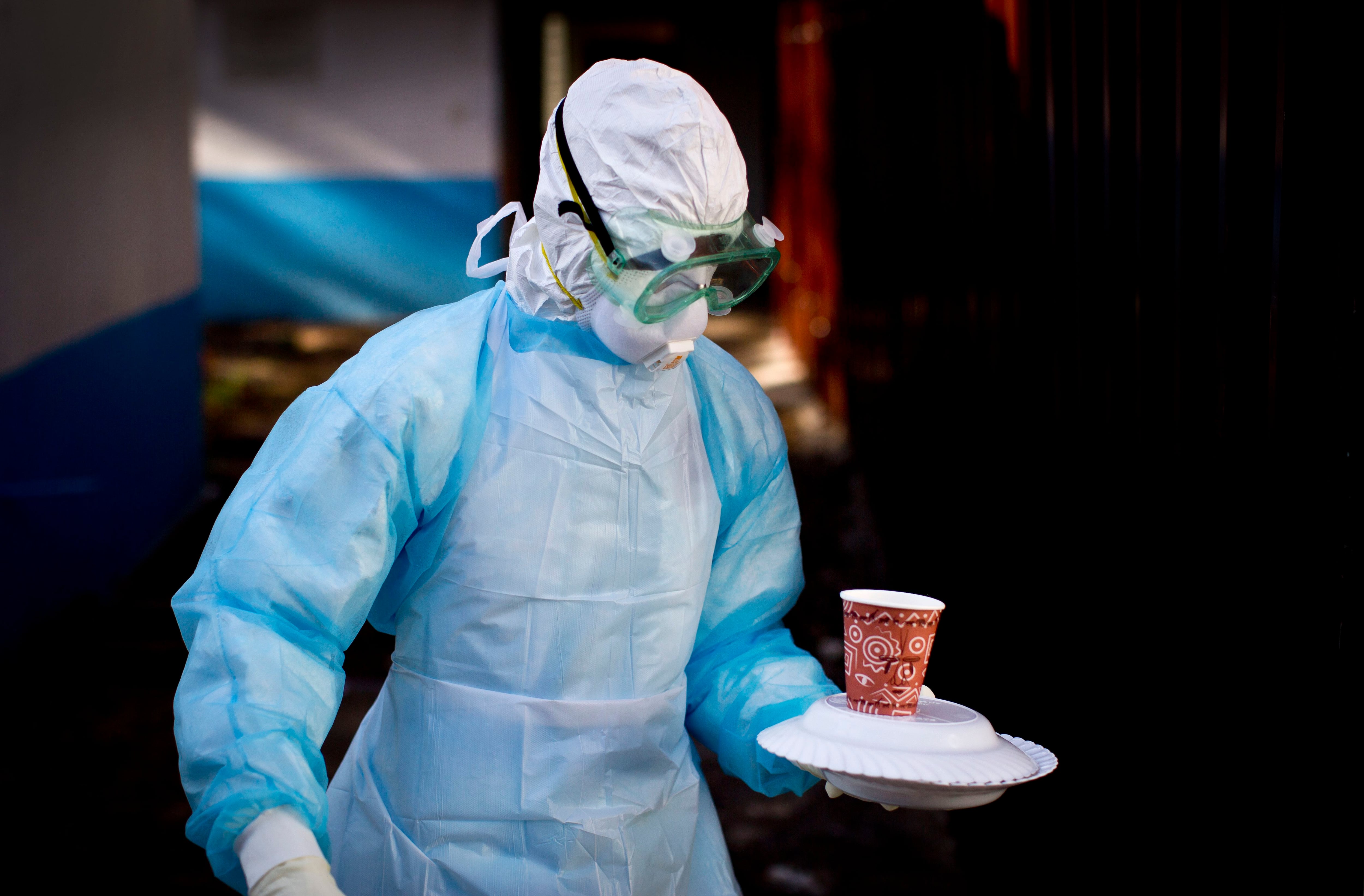 Un trabajador médico de la unidad de Prevención y Control de Infecciones lleva una comida a una tienda de campaña de aislamiento que alberga a un hombre que está en cuarentena por el virus de marburgo (AP Foto/Ben Curtis, Archivo)