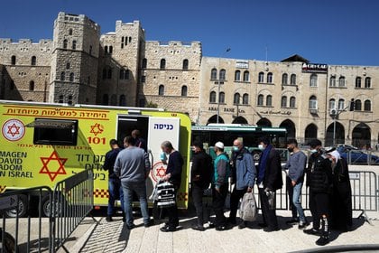 Personas hacen cola para vacunarse en un vehículo de vacunación móvil, en Jerusalén el 26 de febrero de 2021. REUTERS / Ammar Awad