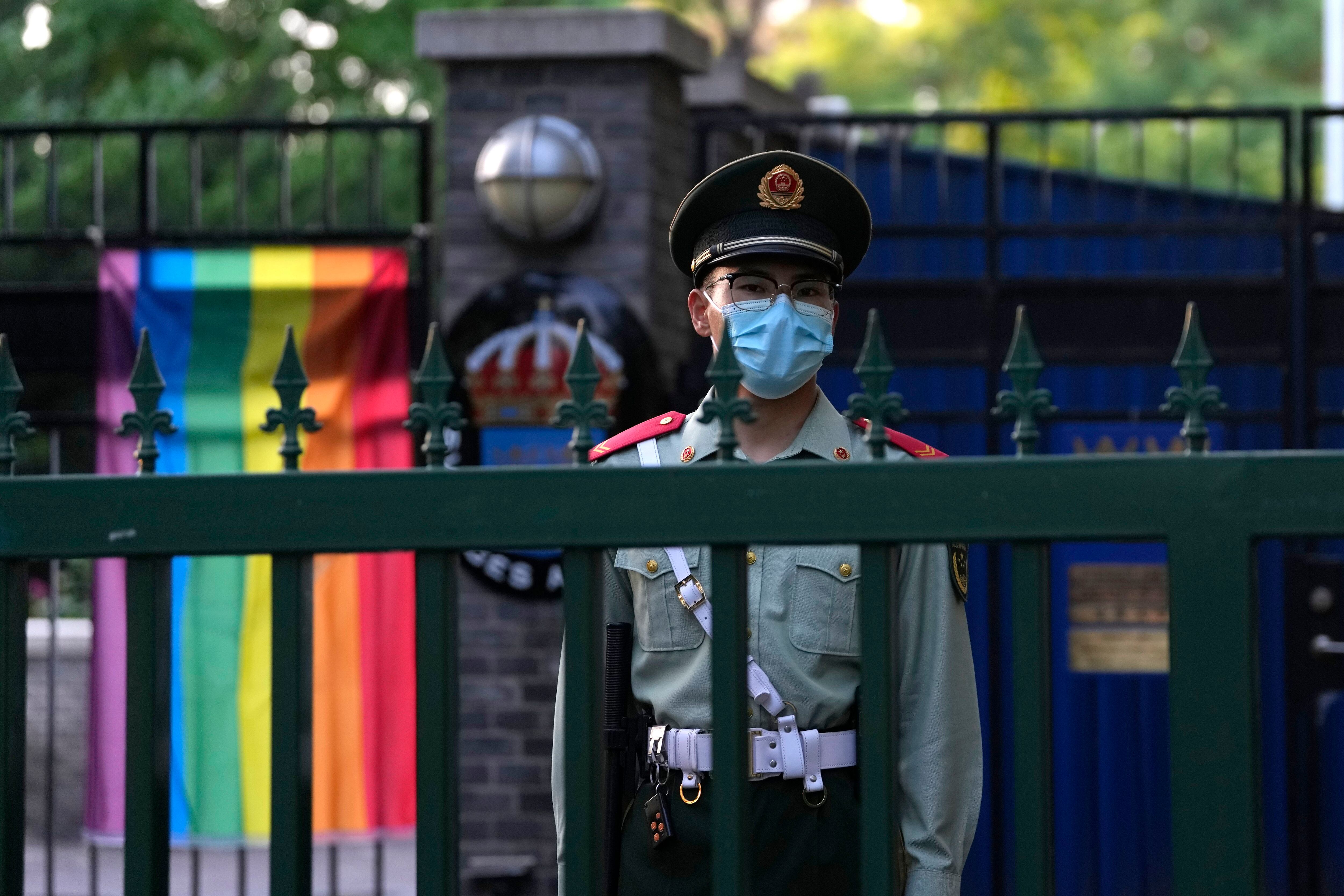 Un policía paramilitar chino hace guardia frente a la embajada sueca durante la ceremonia inaugural de la Semana de la Diversidad en Beijing: se convirtió en la organización más reciente que se ve obligada a cerrar bajo una campaña de represión del gobierno del presidente chino Xi Jinping. (AP Foto/Ng Han Guan)