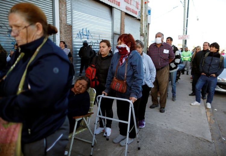 Jubilados y personas con planes de asistencia social hacen cola fuera de un banco, ya que se abrió por primera vez desde la cuarentena obligatoria debido a una cuarentena dispuesta por el brote de COVID-19. Buenos Aires, Argentina, 3 de abril de 2020. REUTERS / Agustin Marcarian