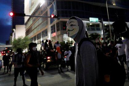 Un manifestante con una máscara de Guy Fawkes asiste a una protesta en Miami, Florida, el 31 de mayo de 2020 en medio de los disturbios que se producen en todo el país tras la muerte de George Floyd bajo custodia policial en Minneapolis (REUTERS/Marco Bello)