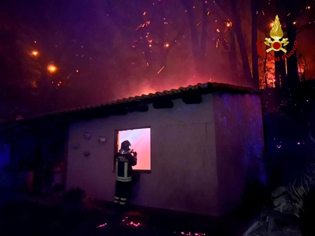 Un bombero comprueba un edificio mientras arde un incendio cerca del pueblo siciliano de Curcuraci, cerca de Messina (Vigili del Fuoco/REUTERS)