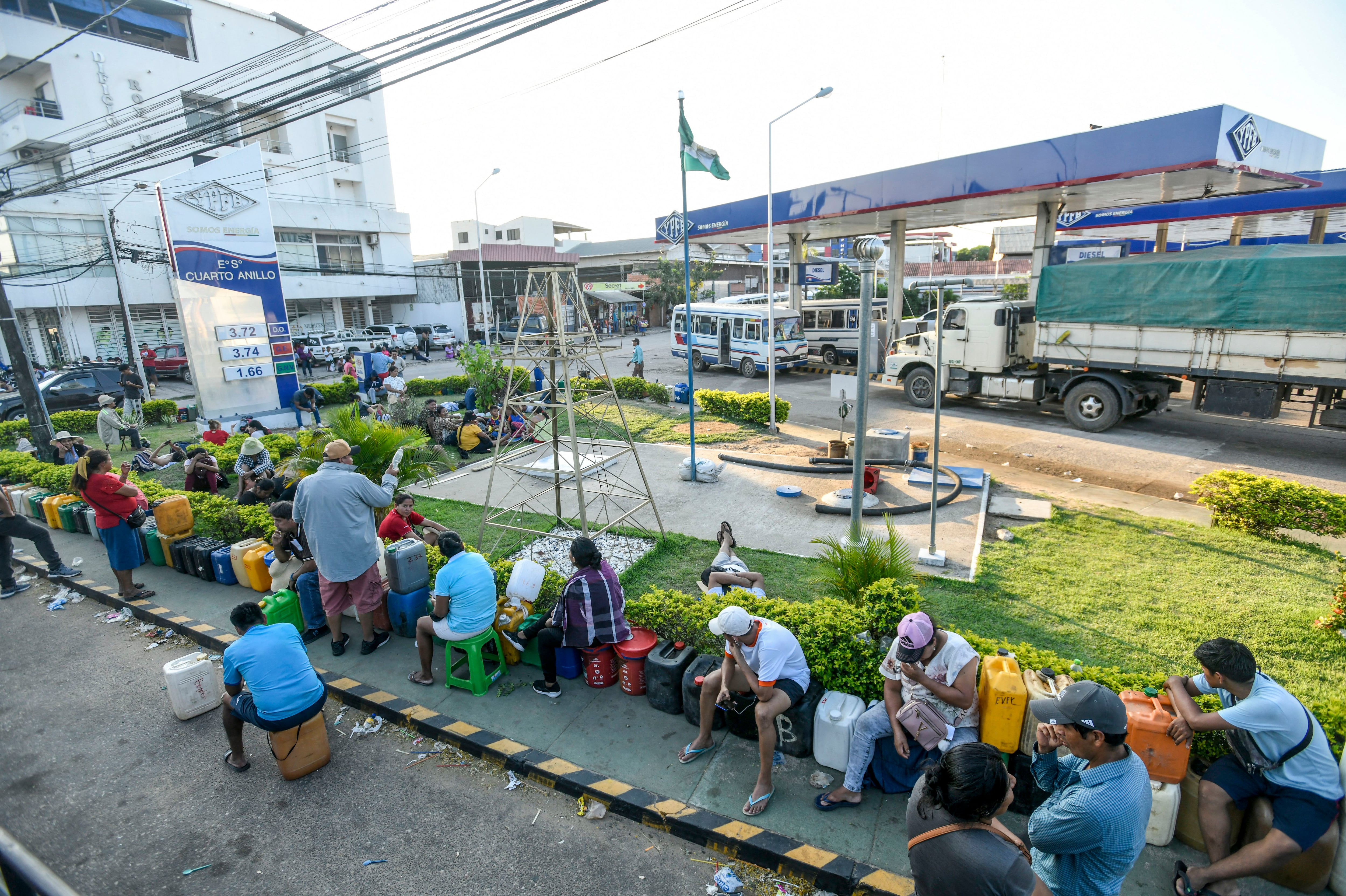 Personas hacen fila para comprar combustible afuera de una estación de servicio en Santa Cruz, Bolivia, el 20 de octubre de 2024. Simpatizantes del expresidente Evo Morales bloquearon las principales vías del país para evitar su posible arresto por presunto abuso sexual de menores. (Foto por RODRIGO URZAGASTI / AFP). 