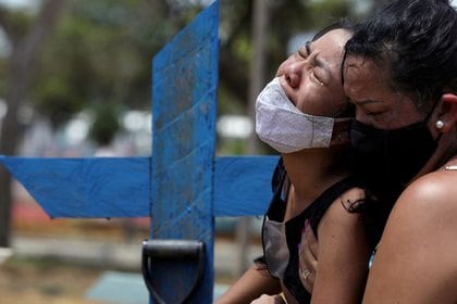 Imagen de archivo de dos personas llorando por la muerte de un familiar en el cementerio Parque Taruma de Manaos, Brasil. 17 enero 2021. REUTERS/Bruno Kelly