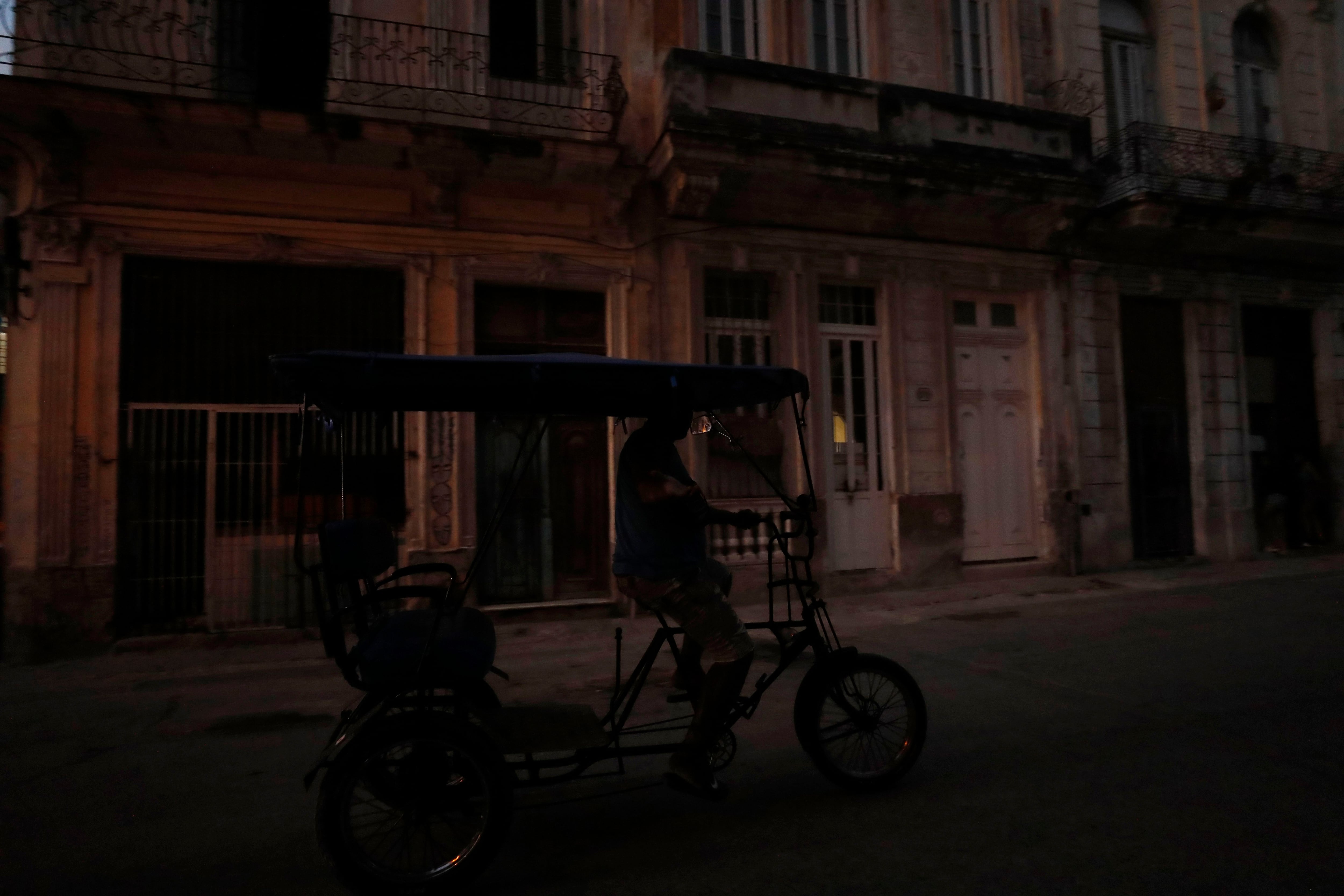 Un bicitaxi que transita por una calle oscura debido a un apagón, en La Habana (EFE/Yander Zamora)
