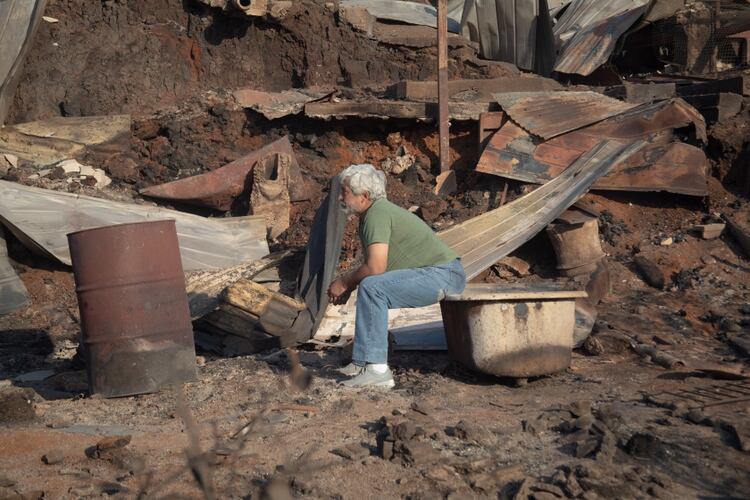 Un hombre mira la destrucción causada por el fuego (AFP)