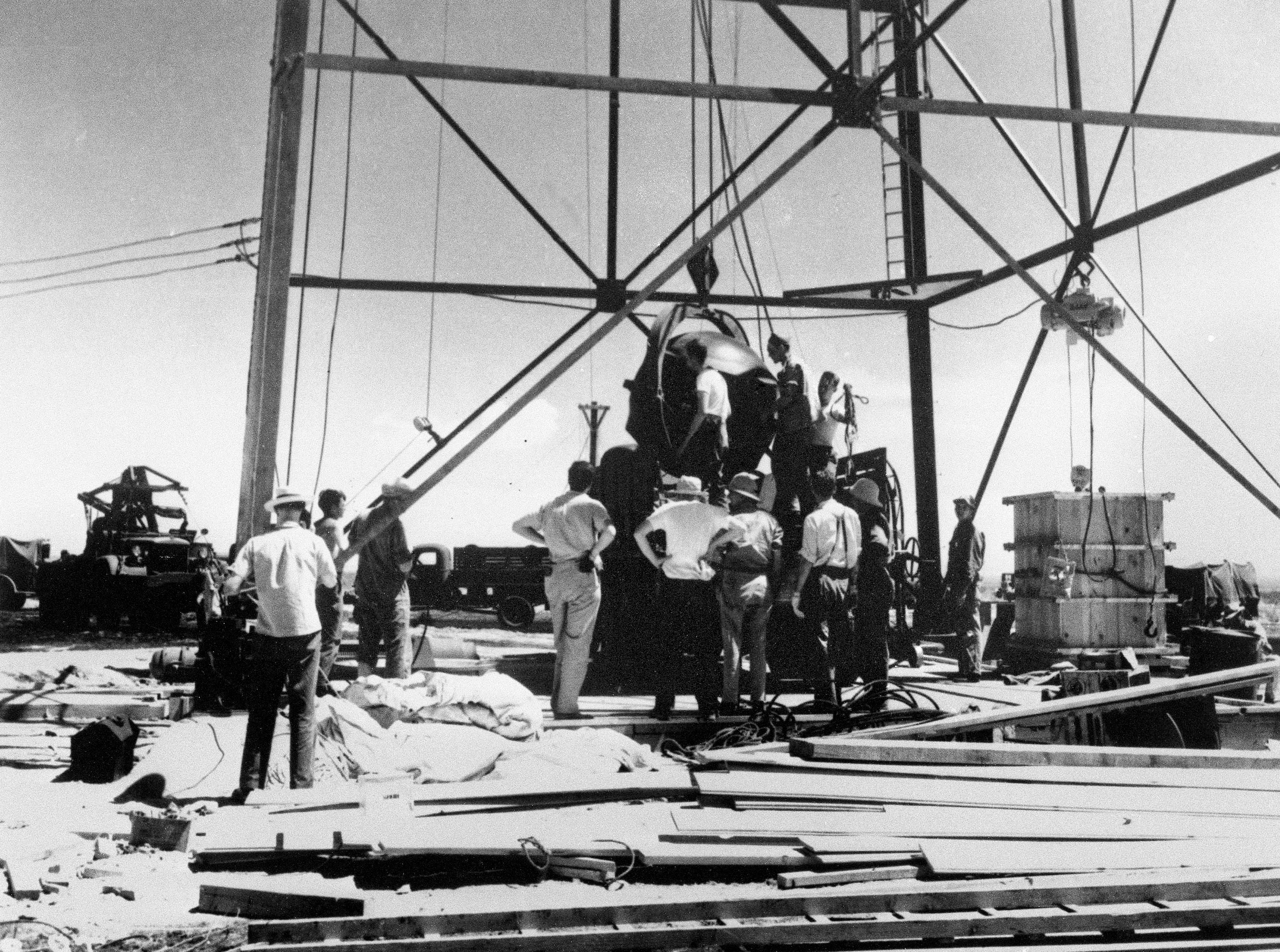 Científicos y otros trabajadores manipulan la primera bomba atómica del mundo para levantarla sobre una torre de 100 pies en el sitio de prueba Trinity cerca de Alamagordo, Nuevo México (AP)