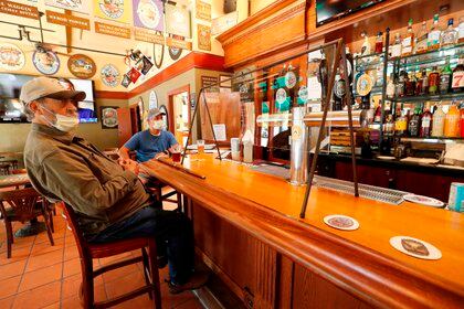 Fotografía de archivo del 21 de mayo de 2020 que muestra a clientes en un bar durante la fase 2 de reapertura de restaurantes en Napa, California, Estados Unidos (EFE/ John G. Mabanglo/ archivo)
